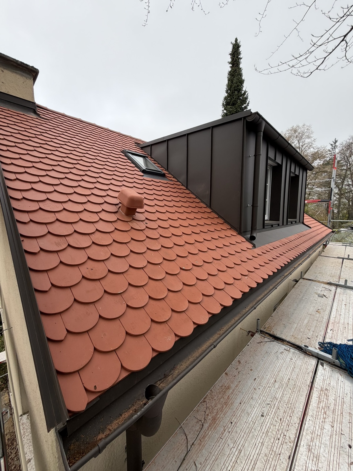 Die fertige Nordseite: Biberschwanz in Naturrot, daneben die neue Stehfalz-Gaube.
