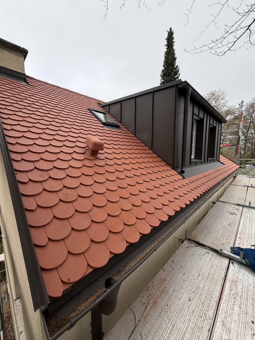 Die fertige Nordseite: Biberschwanz in Naturrot, daneben die neue Stehfalz-Gaube.