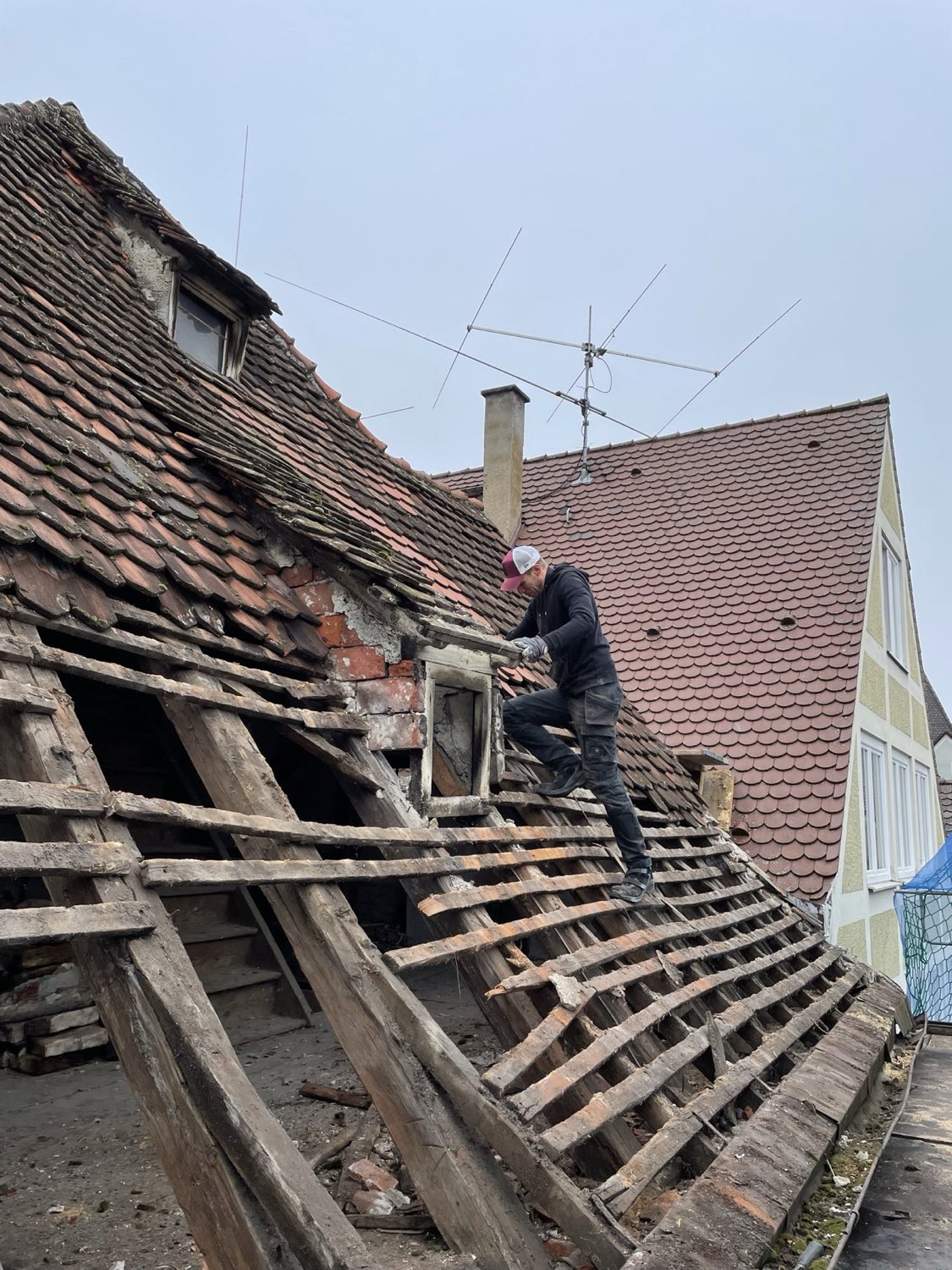 Rückbau: die alte, schadhafte Eindeckung wird abgetragen, der historische Dachstuhl liegt frei.